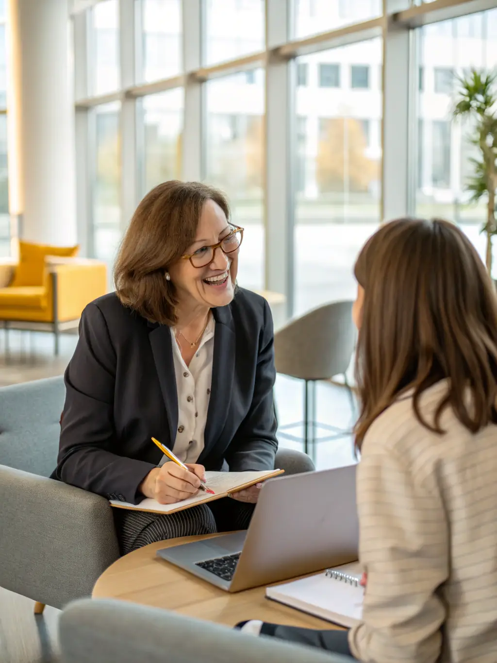 A professional IT coach smiling confidently while reviewing a resume with a client in a modern office setting, symbolizing personalized career guidance.